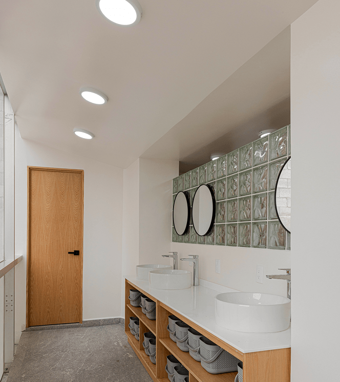 Baño compartido en coliving Roma Norte con lavabo, regadera y diseño funcional